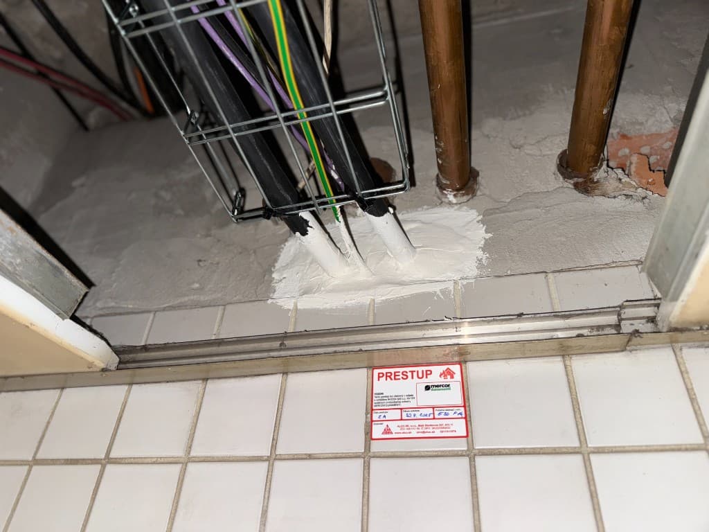 Certifikovaný požiarny prestup – káble a medené potrubia cez strop, protipožiarná výplň, štítok na dlažbe. ALCO.SK.