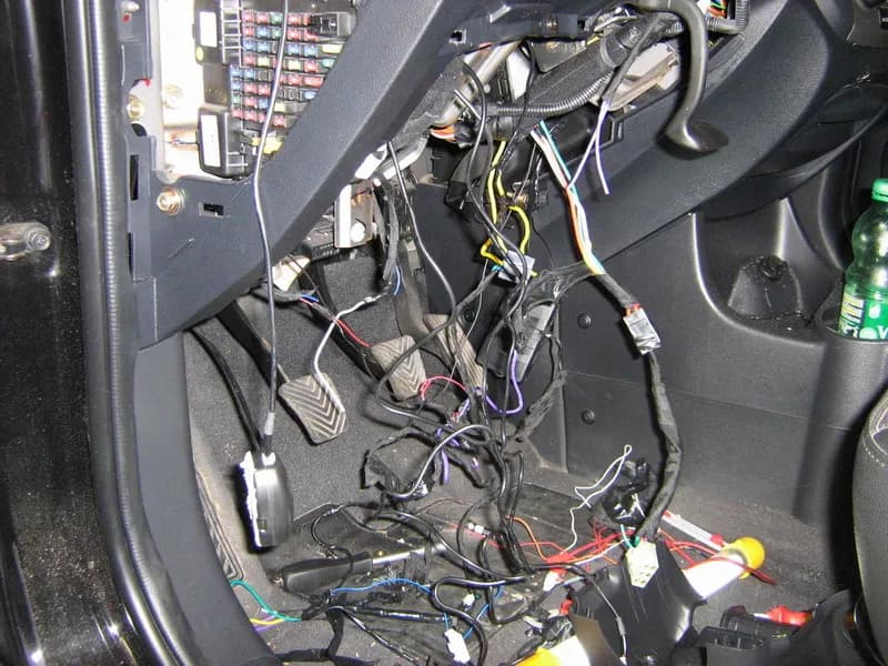 Neodborná montáž – spodok dashboardu, neporiadok a odkryté vodiče