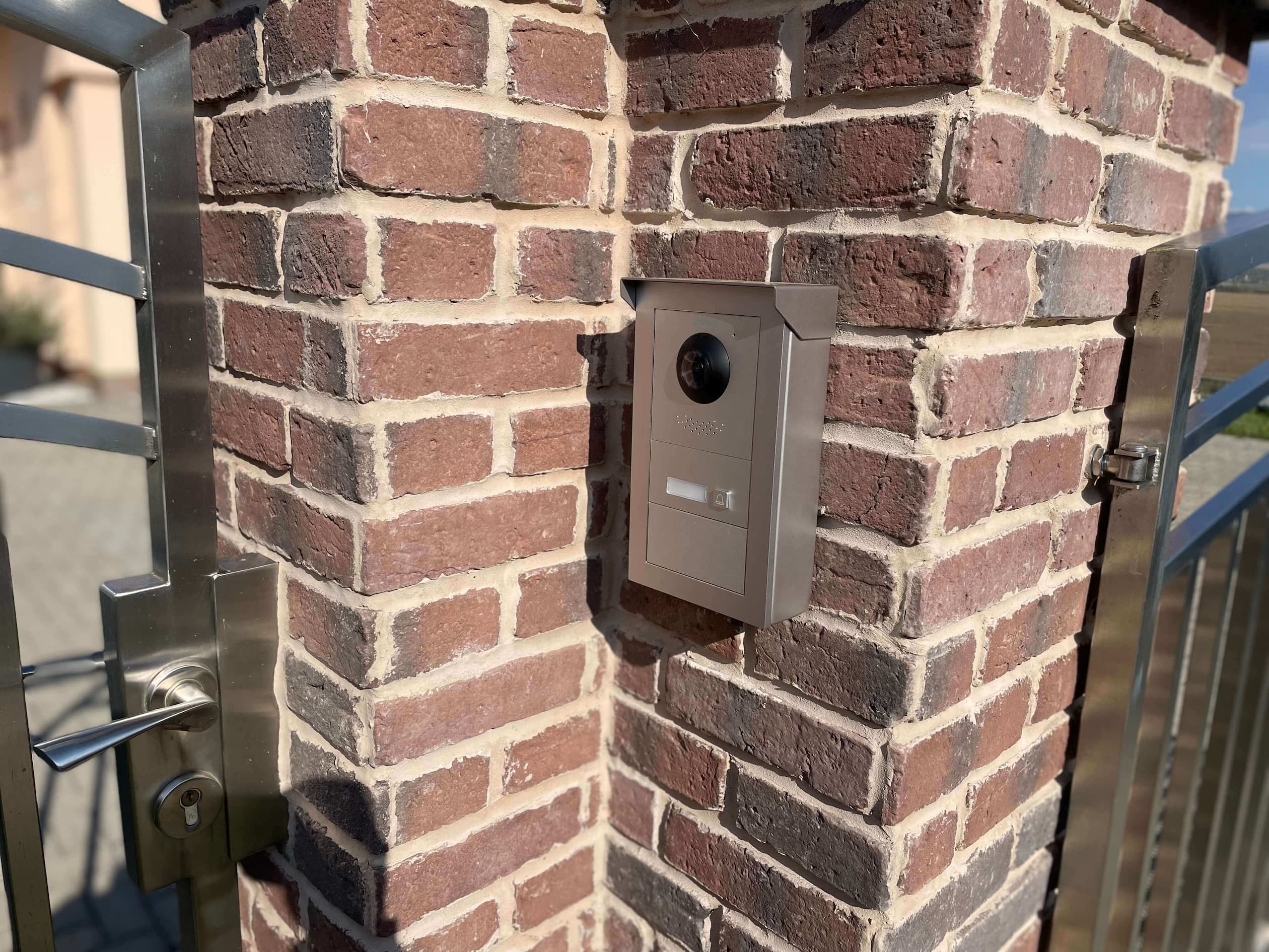 Videovrátnik na tehlovom stĺpe s nerezovou bránou – bezpečný vstupný systém s kamerou a zvončekom. ALCO.SK