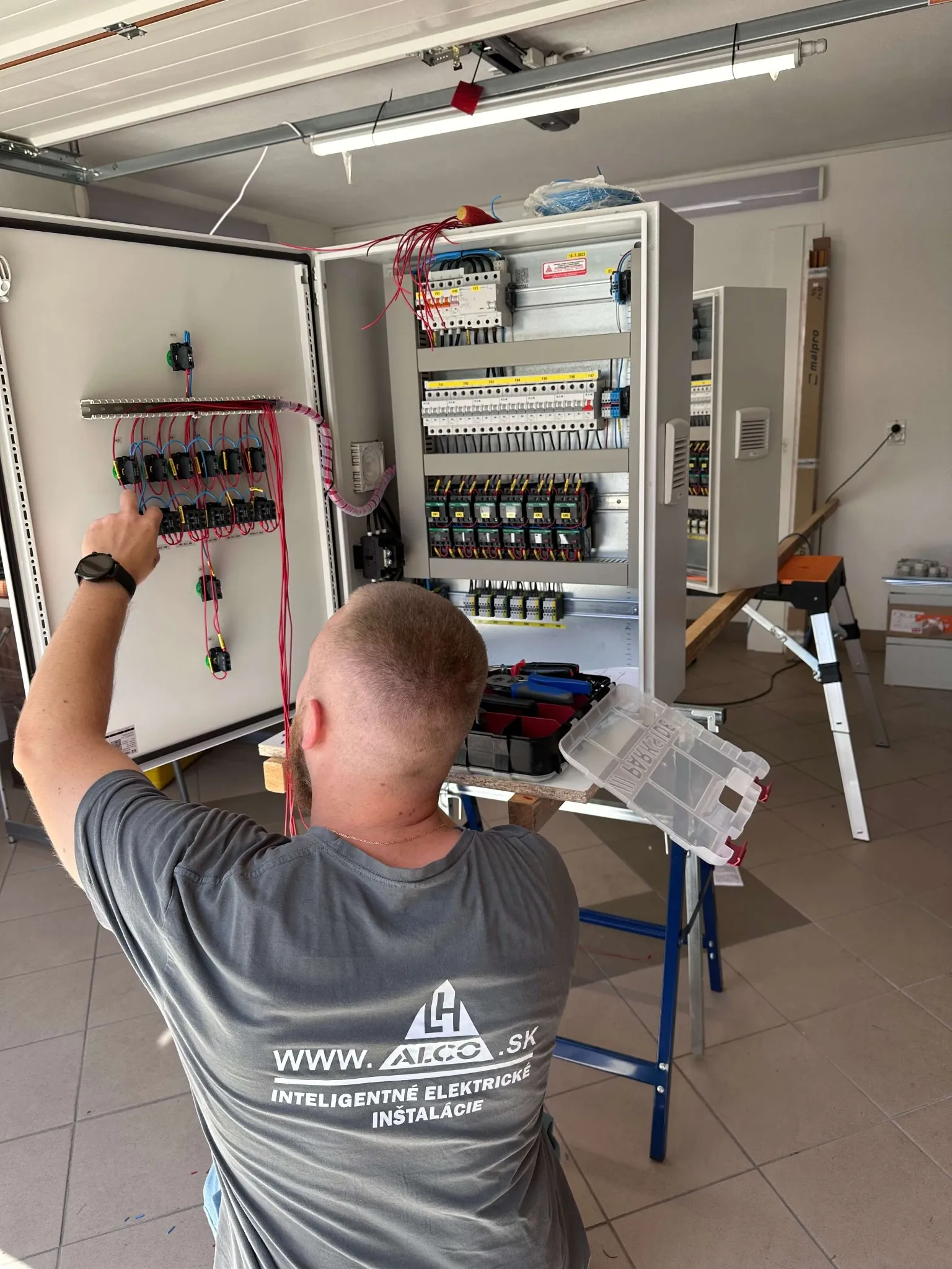 Výroba rozvádzačov NN – elektrikár pri montáži, nízkonapäťové rozvádzače na mieru. ALCO.SK